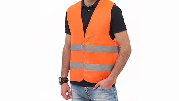 Man wearing an orange high-visibility reflective safety vest for workplace safety