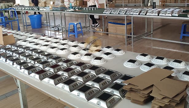 Finished solar road studs ready for packaging on an assembly line
