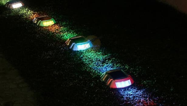 Colorful embedded solar road studs lighting up garden at night