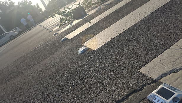 Embedded solar road studs installed on zebra crossing during daytime
