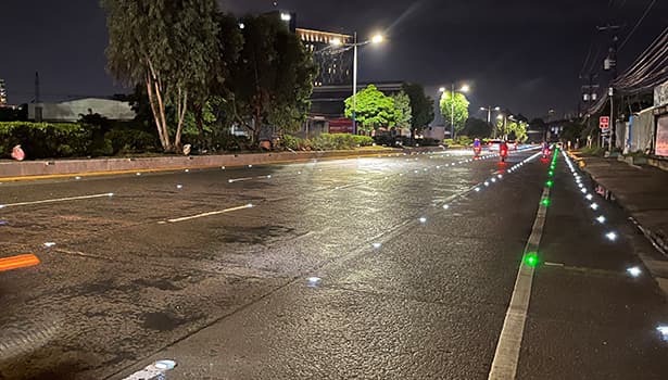 Solar road studs installation on municipal road at night with multi-color lights
