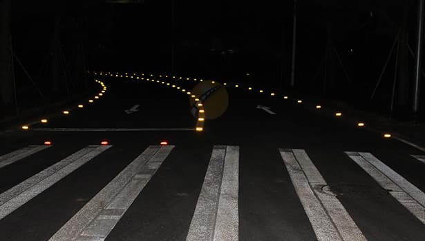 Solar road studs installed at zebra crossing and curve for night visibility