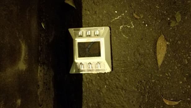 Close-up of solar-powered road stud installed on pavement